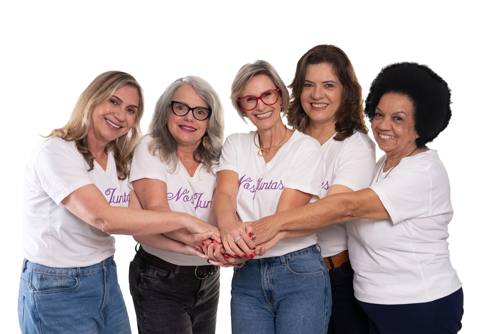 As cinco mulheres do coletivo Nós Juntas — Ana Maria, Betinha, Cleonice, Marisa e Sônia — com as mãos unidas